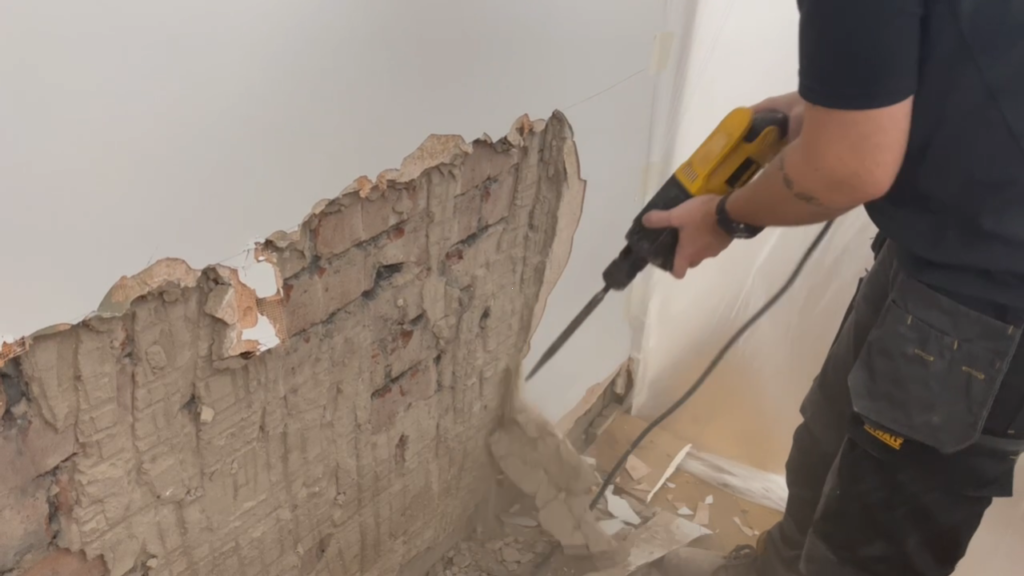 Hacking off damp plaster