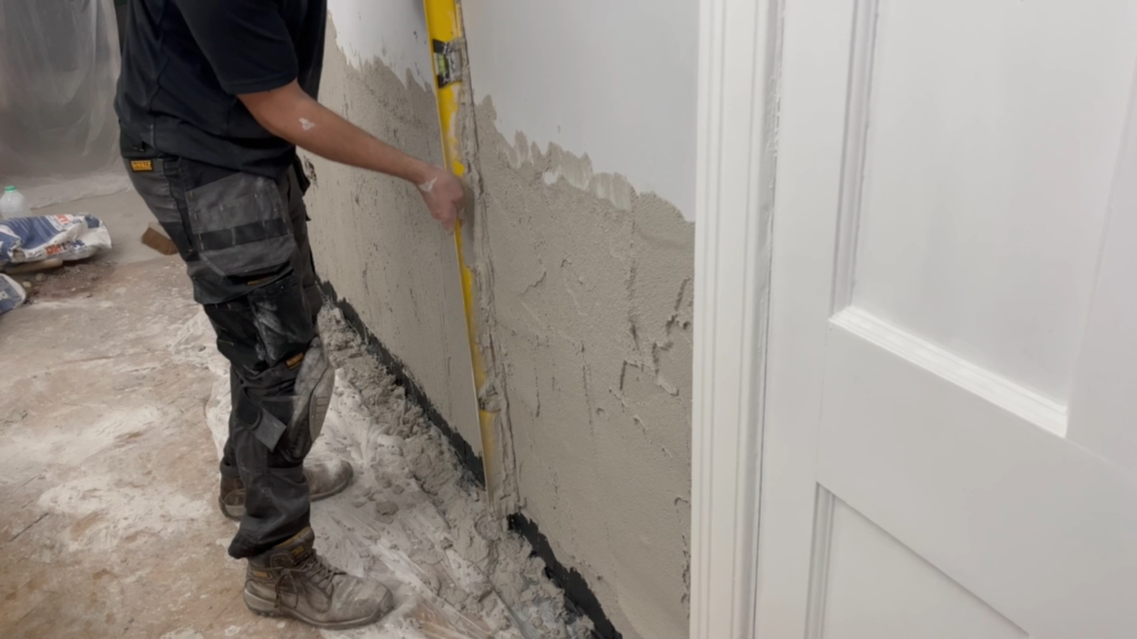 Levelling the undercoat plaster